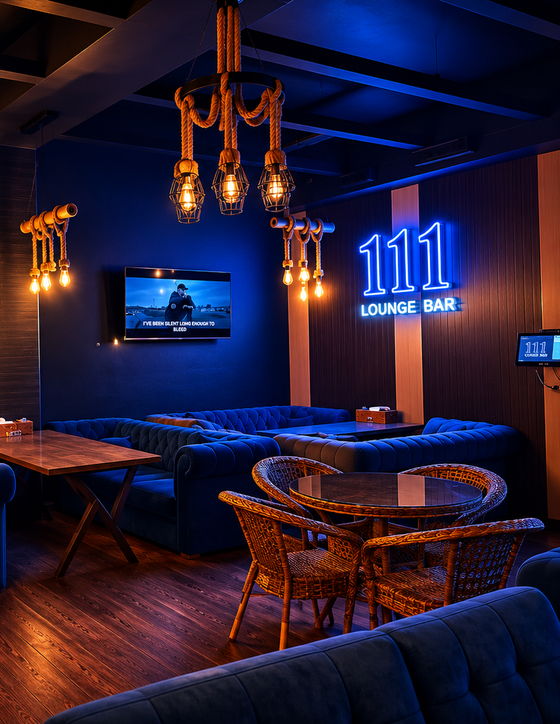 Основной зал 111 Lounge Bar вечером: синий неон с названием заведения, честерфилды и верёвочные лампы